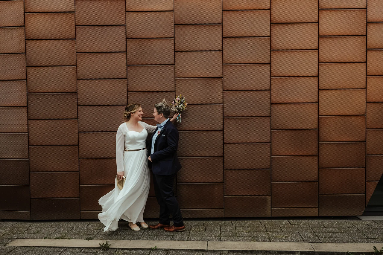 Hochzeitspaar vor einer modernen Kupferfassade in Hamburg
