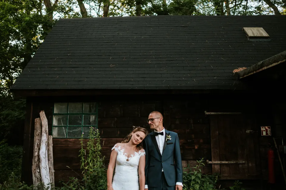 Brautpaar vor einer dunklen Scheune bei einer Landhochzeit