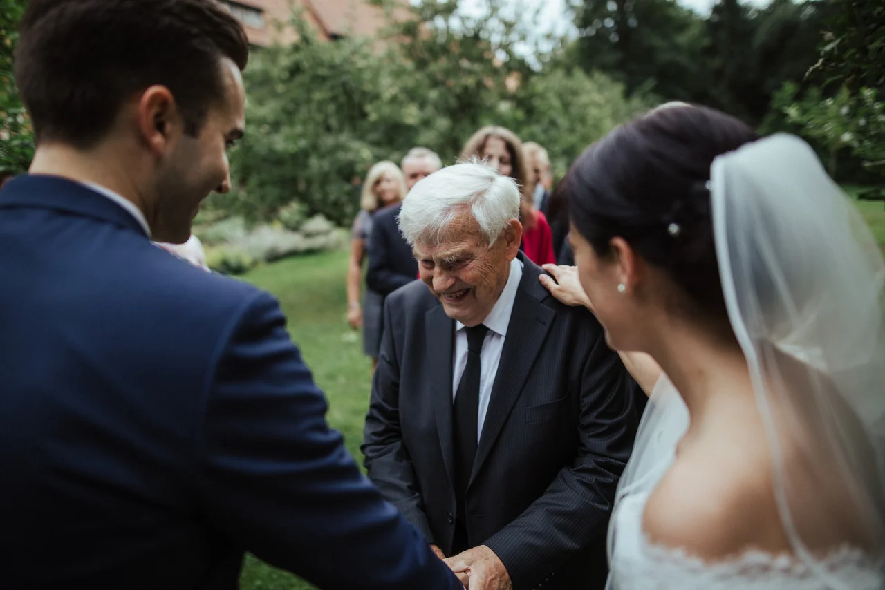 Emotionaler Moment mit Großvater und Brautpaar bei einer Hochzeit