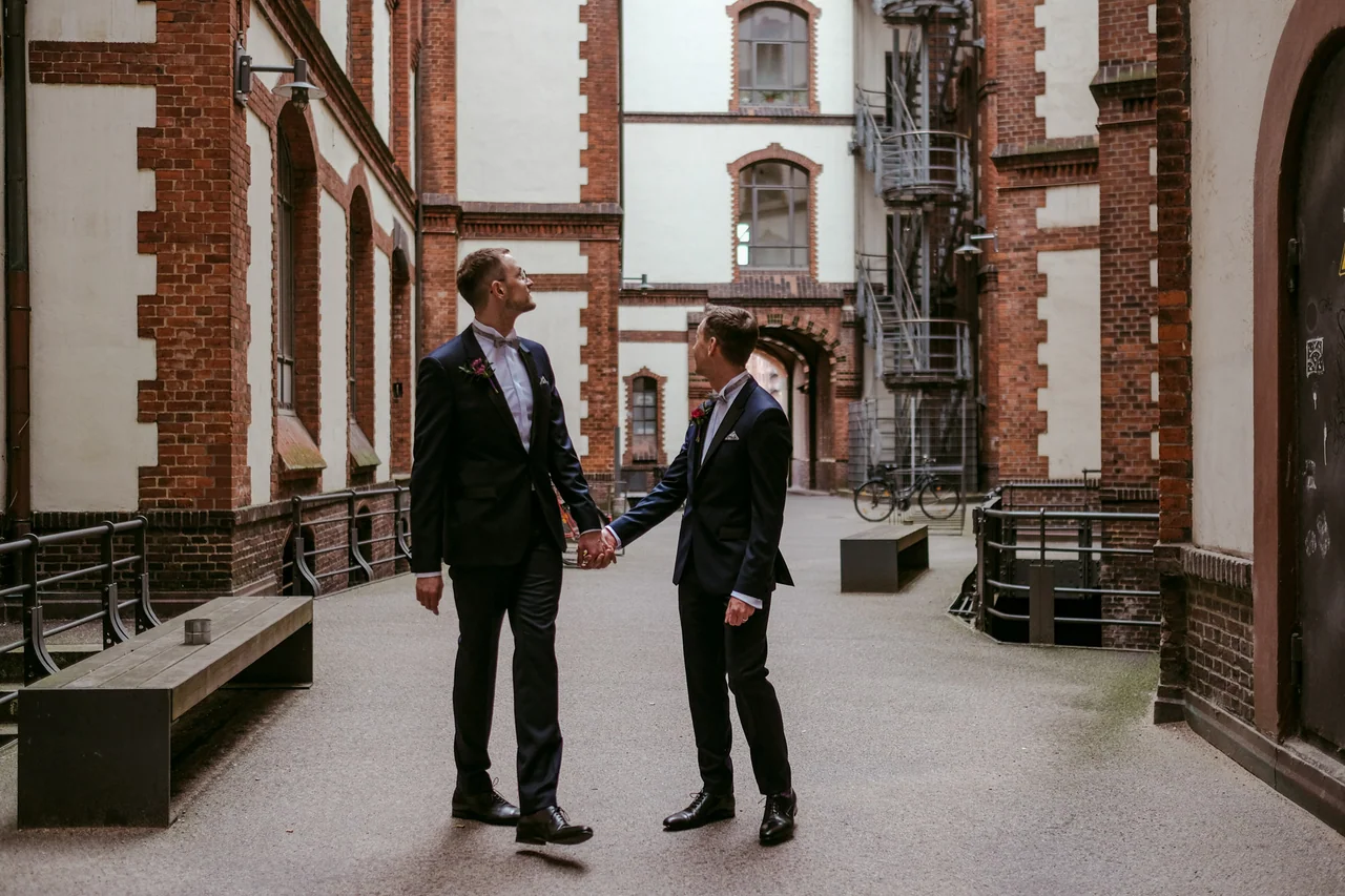 Zwei Männer nach ihrer Hochzeit in einem Hamburger Backsteinhof