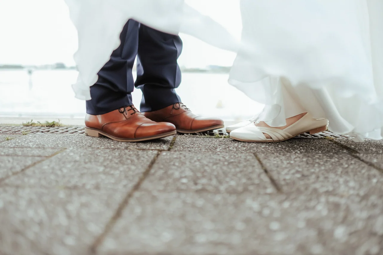 Brautschuhe und Kleid als Detail eines ungestellten Hochzeitsfotos